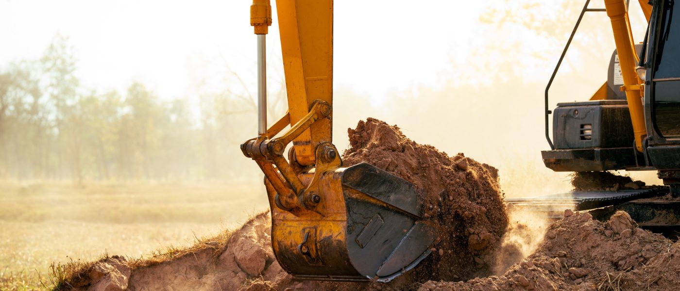 Backhoe working by digging soil at construction site. Crawler excavator digging on demolition site.