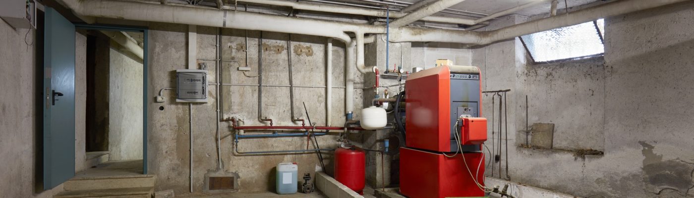 Basement with red heating boiler in old house interior