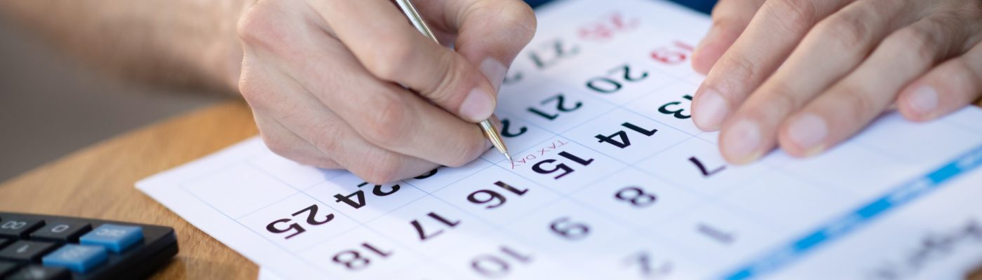 Businessman near calendar working on schedule
