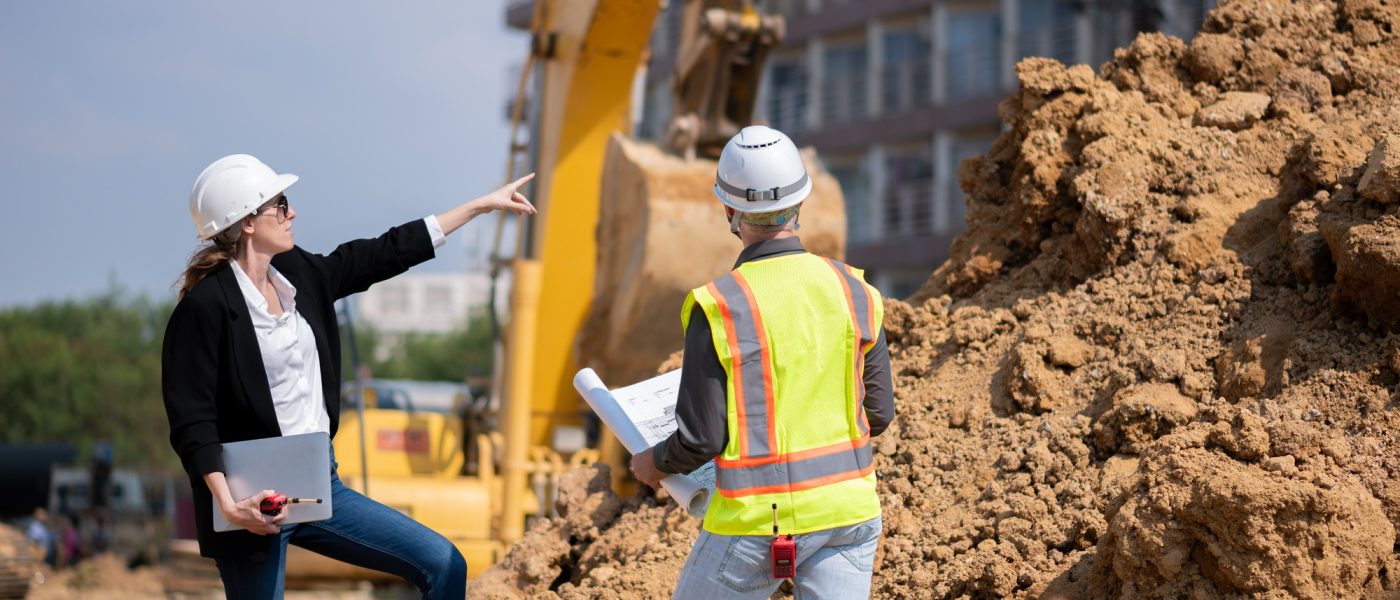 Construction Manager and engineer working construction site blueprint and laptop for survey inspecti