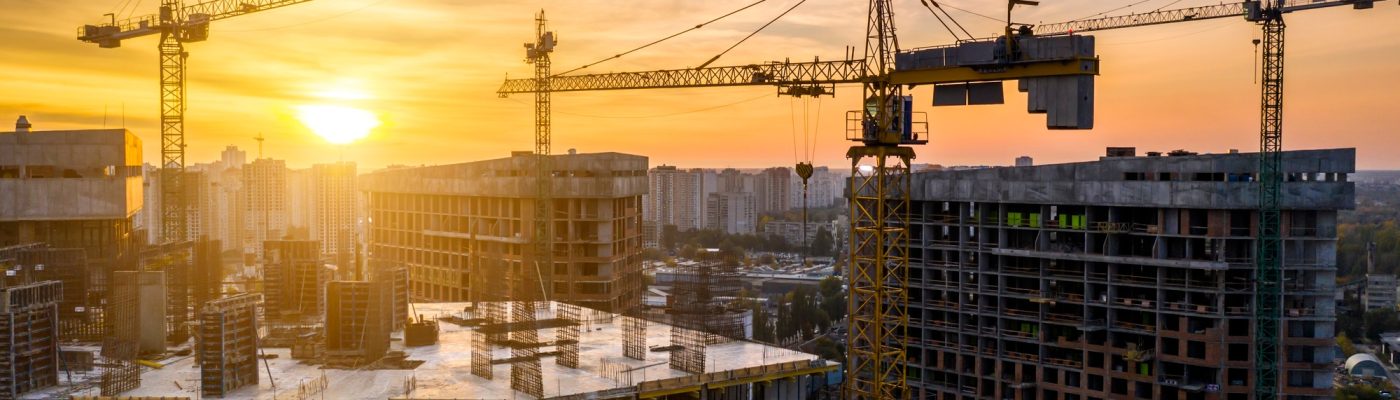 Construction site with cranes at sunset. Construction of an apartment building