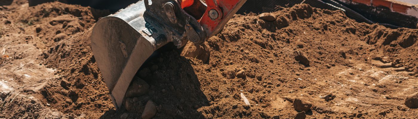 Excavator shovel digging on dirt