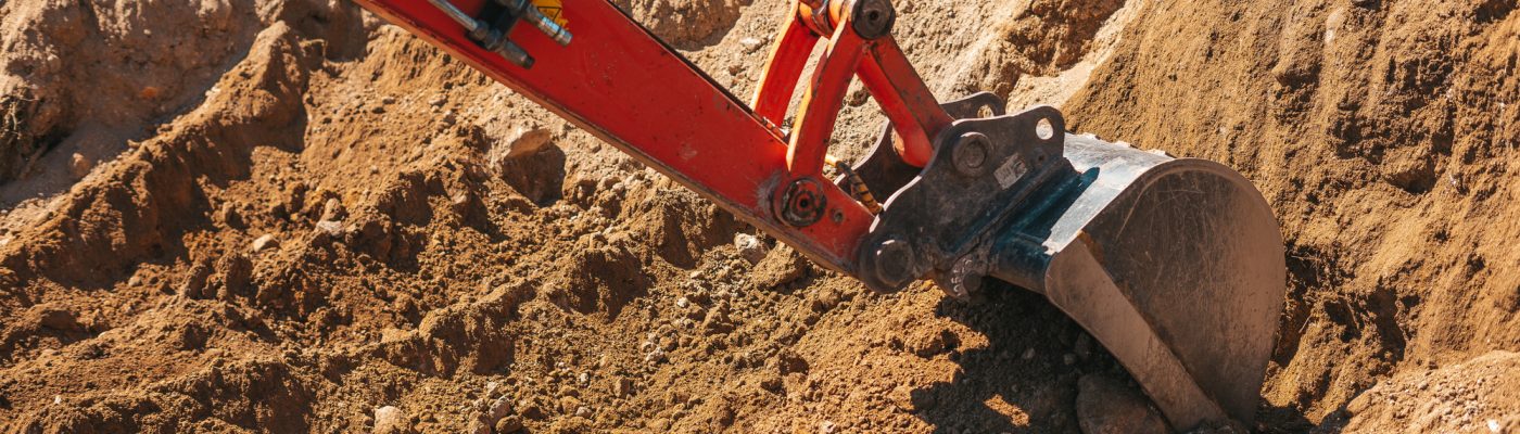 Excavator shovel digging on dirt